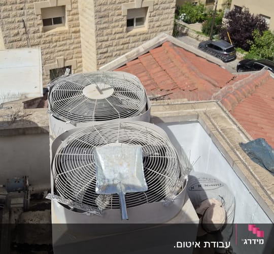 מערכת מיזוג אוויר על גג עם אדם עובד